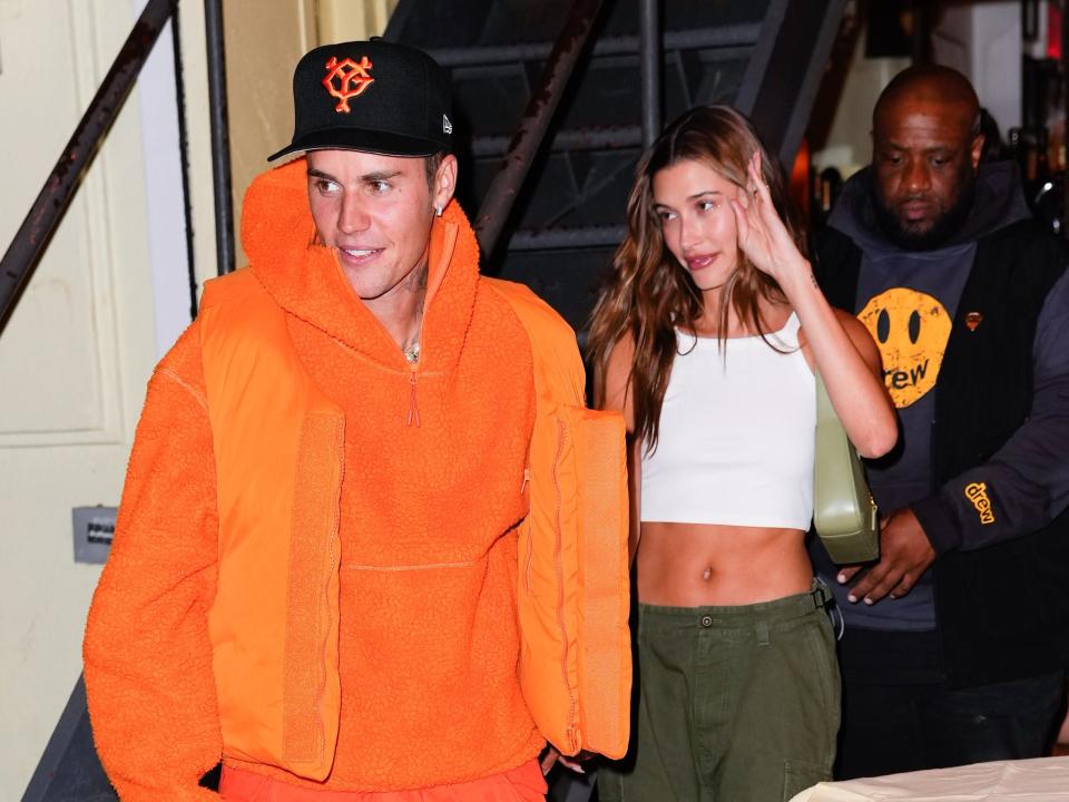 justin bieber wearing an all orange outfit and hailey