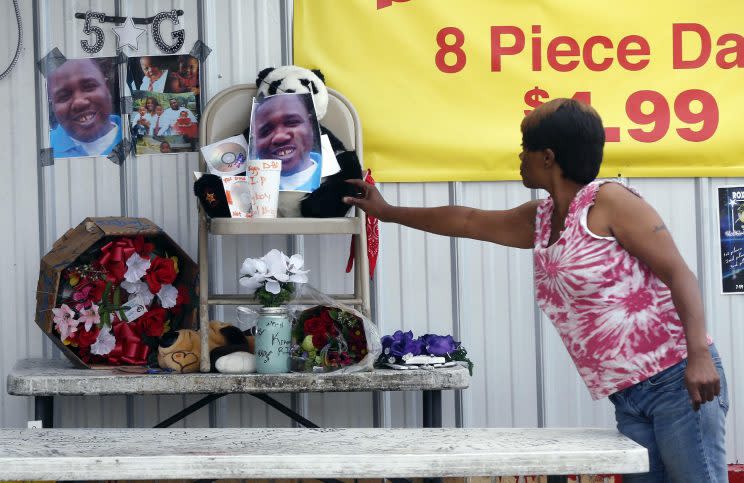 Nishka Johnson touches a makeshift memorial for Alton Sterling, outside a convenience store in Baton Rouge, La., Wednesday, July 6, 2016. (Photo: Gerald Herbert/AP)