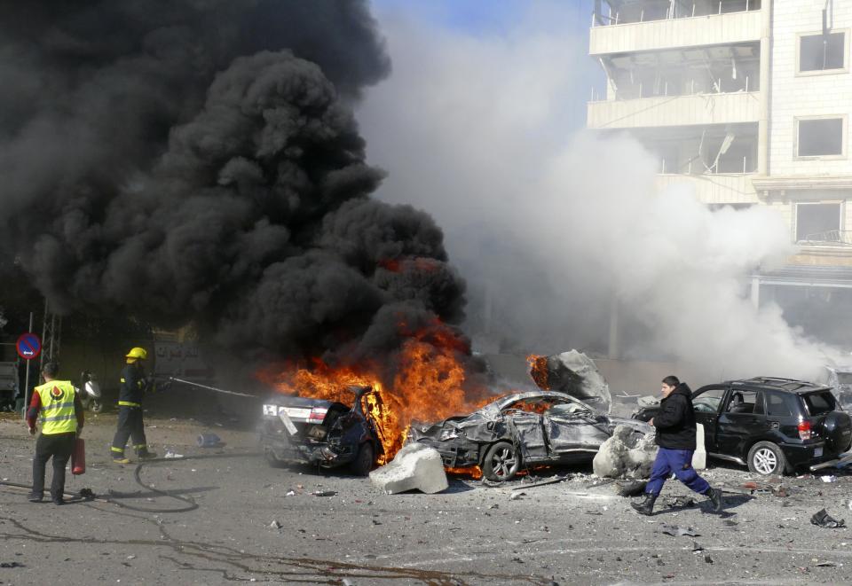 Civil defence members put out a fire at the site of an explosion near the Iranian cultural centre in the southern suburbs of Beirut February 19, 2014. (REUTERS/Stringer)