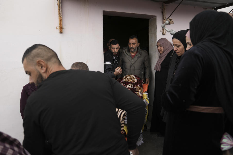 Mourners carry the body of Palestinian Fulla al-Masalmeh,15, during her funeral in the West Bank village of Beit Awwa, Tuesday, Nov. 15, 2022. The Palestinian Health Ministry says Israeli forces shot and killed a 15-year-old Palestinian girl during a pre-dawn raid in the occupied West Bank. The circumstances surrounding the death of the teenage girl in the city of Beitunia in the central West Bank, identified by Palestinian health officials as Fulla al-Masalmeh, were not fully clear. The Israeli military said soldiers opened fire on a vehicle that was accelerating toward them after they signaled for it to stop. The military said it was investigating, and declined to comment further. (AP Photo/Mahmoud Illean)