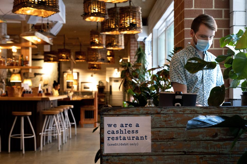 Brad Lavelle, a shift lead at Bartaco, works the from desk at the restaurant in Arlington, Va., on Thursday, Sept. 2, 2021. The restaurant uses an automated app for ordering and payments, accessed via a barcode attached to tables, and instead of servers they use "food runners" to get the orders to the tables. (AP Photo/Jacquelyn Martin)