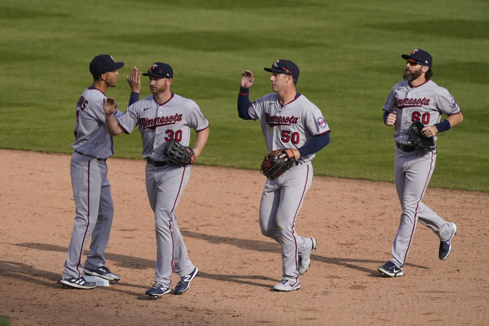 Minnesota Twins shortstop Andrelton Simmons, left, greets outfielders Kyle Garlick (30), Brent Rooker (50) and Jake Cave after their win over the Detroit Tigers in a baseball game, Monday, April 5, 2021, in Detroit. (AP Photo/Carlos Osorio)