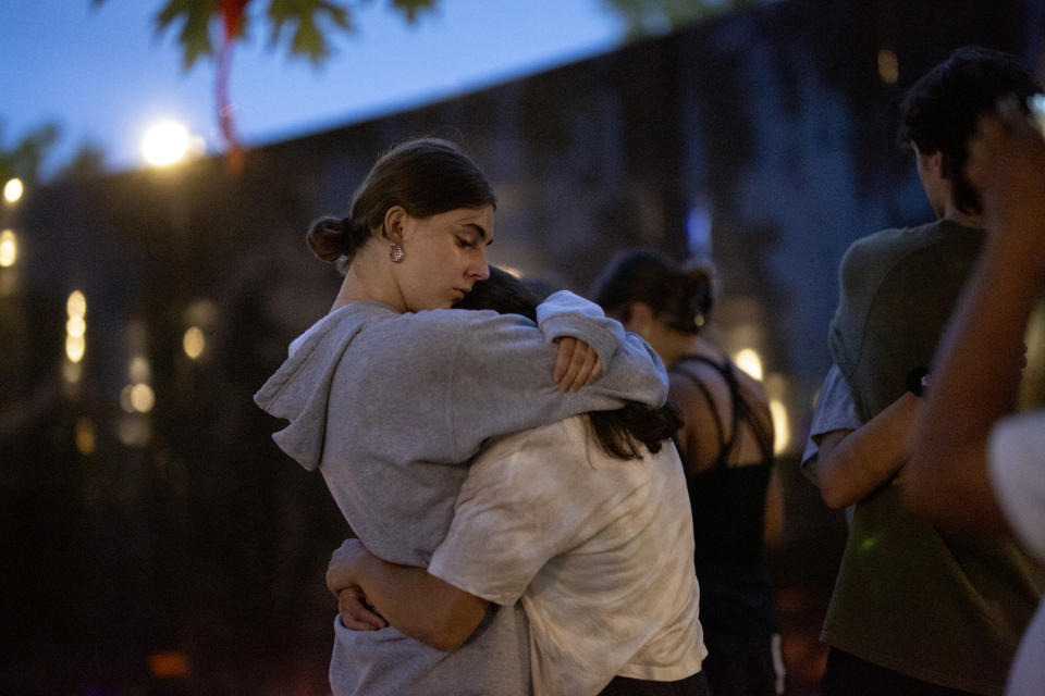 People gather for a candelight vigil near the scene of a mass shooting yesterday at a Fourth of July parade, on July 5, 2022 in Highland Park, Illinois. Authorities have charged Robert “Bobby” E. Crimo III, 22, with seven counts of first-degree murder in the attack that also injured 47, according to published reports.