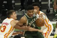 Milwaukee Bucks' Giannis Antetokounmpo tries to get past Atlanta Hawks' Bogdan Bogdanovic (13) and John Collins during the first half of Game 1 of the NBA Eastern Conference basketball finals game Wednesday, June 23, 2021, in Milwaukee. (AP Photo/Morry Gash)