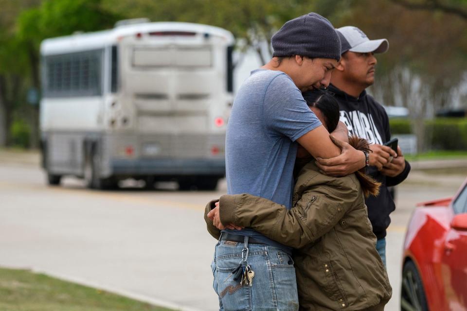 FILE - In this April 3, 2019, file photo, a couple who did not want to give their names embrace outside CVE Group as a bus from LaSalle Corrections Transport departs the facility in Allen, Texas. Immigrant families and advocates are warning about planned arrests around the country by the Immigration and Customs Enforcement agency.