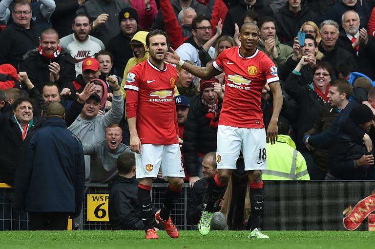 Manchester United's Juan Mata (L) celebrates with teammate Ashley Young after scoring a goal during their English Premier League match against Manchester City, at Old Trafford in Manchester, north-west England, on April 12, 2015