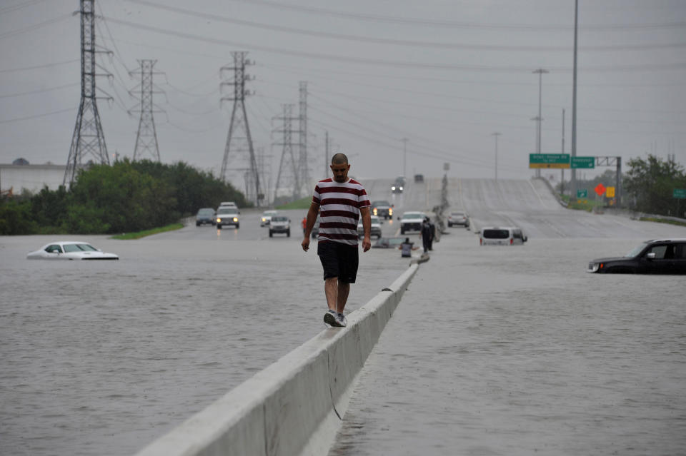 <p>A stranded motorist escapes floodwaters on Interstate 225 after Hurricane Harvey inundated the Texas Gulf coast with rain causing mass flooding, in Houston, Texas, Aug. 27, 2017. (Photo: Nick Oxford/Reuters) </p>