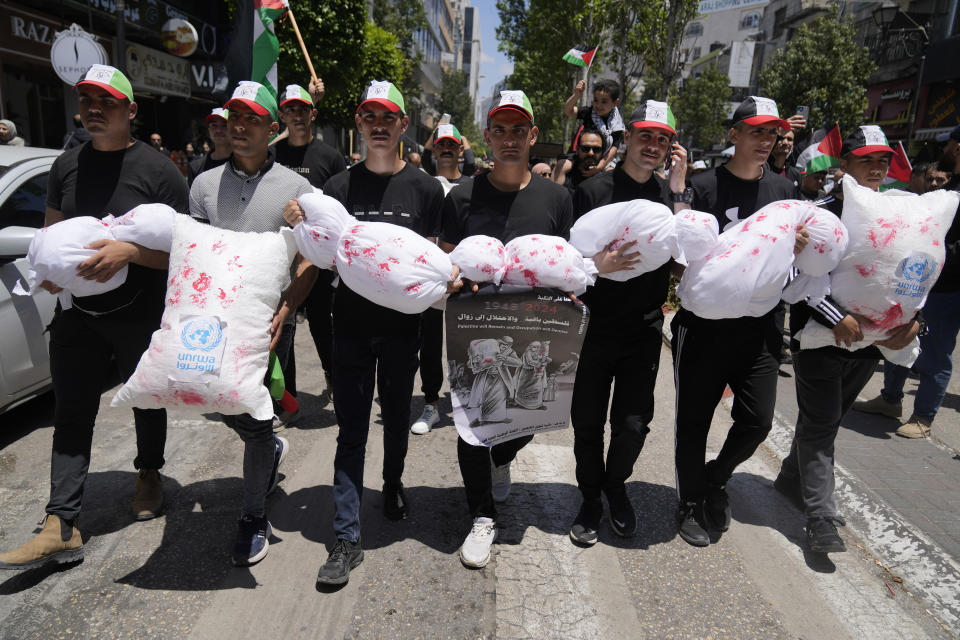 Palestinians carry bloodstained mock children bodies during a mass ceremony to commemorate the Nakba Day, Arabic for catastrophe, in the West Bank city of Ramallah, Wednesday, May 15, 2024. Palestinians are marking 76 years of dispossession on Wednesday, commemorating their mass expulsion from what is today Israel, as a potentially even larger catastrophe unfolds in Gaza, where more than half a million of people have been displaced in recent days by fighting. (AP Photo/Nasser Nasser)