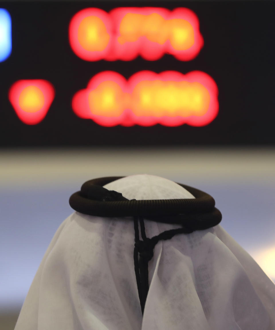 An Emirati trader looks at the latest numbers in red on the screen, at the Dubai Financial Market in Dubai, United Arab Emirates, Monday, March 9, 2020. Saudi Arabia closed off air and sea travel to nine countries affected by the new coronavirus Monday as Mideast stock markets tumbled over fears about the widening outbreak's effect on the global economy. (AP Photo/Kamran Jebreili)