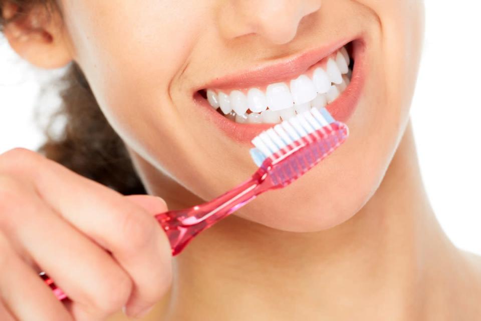 smiling woman brushing teeth