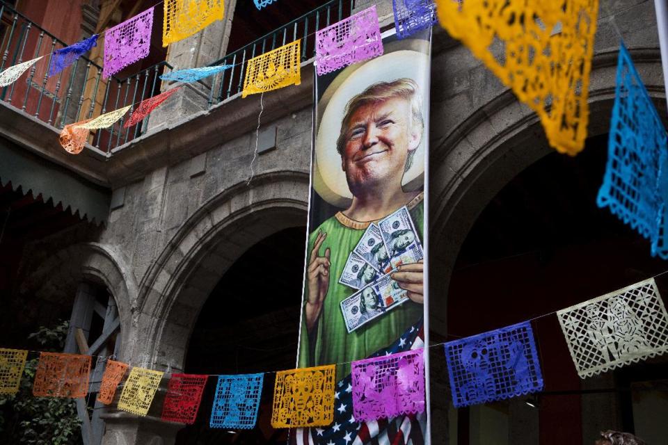 FILE - In this Nov. 10, 2016 file photo, a banner with an image of Donald Trump to promot an exhibition that features dozens of works by Mexican and international cartoonists, mocking amongst other things the U.S. president derogatory statements about Mexicans and his plans to build a wall between the two countries, in downtown Mexico City. If there are plans to take the Trump brand to Mexico, it could be tough going due to widespread popular anger toward the president for his comments disparaging Mexican immigrants who come to the United States illegally, his threats to tear up the North American Free Trade Agreement and his vows to make Mexico pay for the border wall. (AP Photo/Rebecca Blackwell, File)
