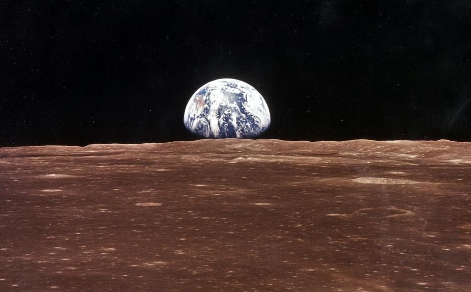 A view of the Earth appears over the Lunar horizon as the Apollo 11 Command Module comes into view of the Moon: NASA/Newsmakers