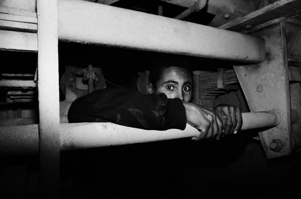 Mohammed, 16, hides under a truck in the port of Tangier, Morocco, in 2004. (Photo: José Colón/MeMo for Yahoo News)