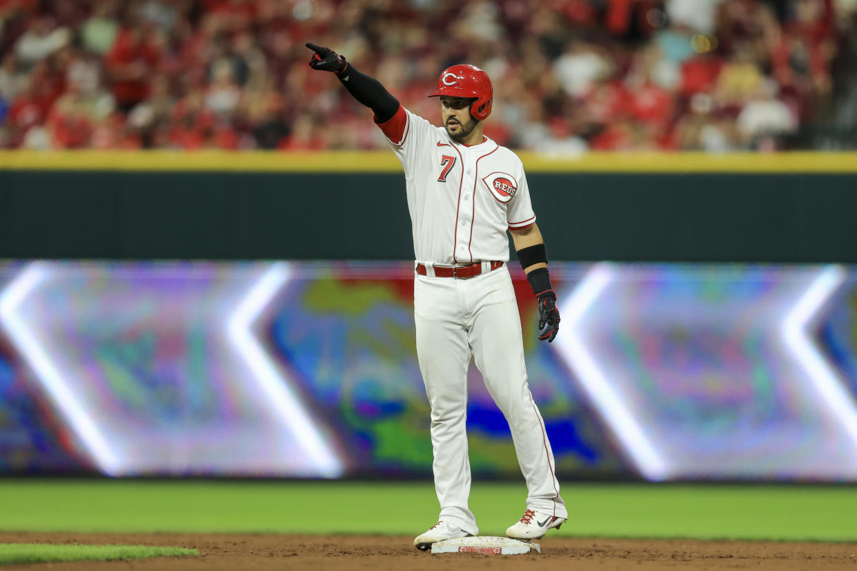 Cincinnati Reds' Eugenio Suarez points to teammates after hitting an RBI-double during the seventh inning of a baseball game against the St. Louis Cardinals in Cincinnati, Friday, July 23, 2021. (AP Photo/Aaron Doster)
