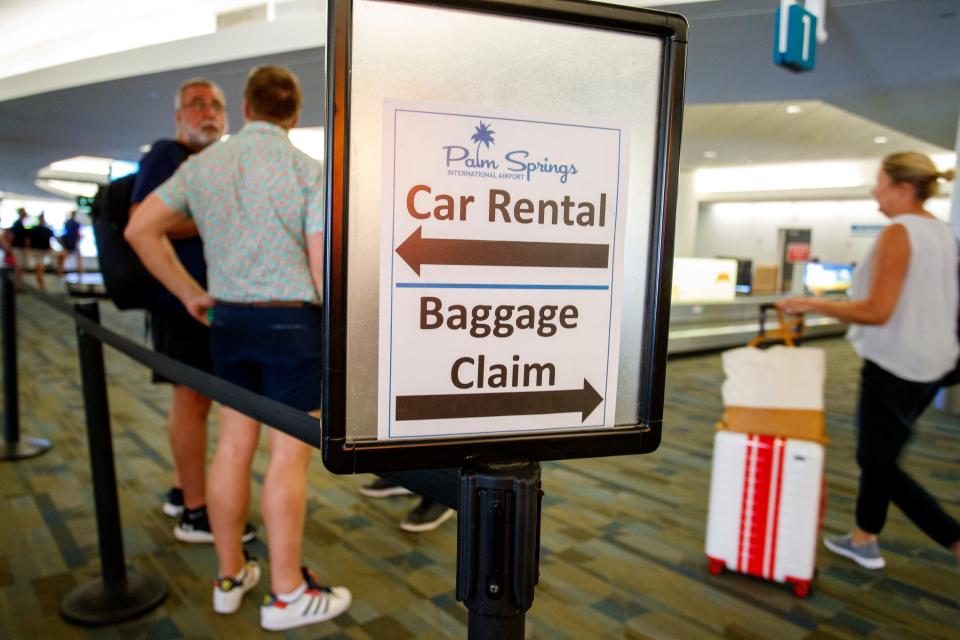 People stand near baggage claim at Palm Springs International Airport in 2022.