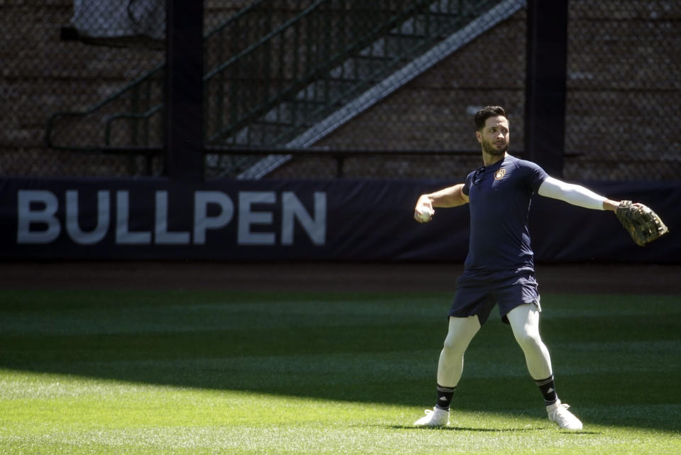 FILE - In this Saturday, July 4, 2020, file photo, Milwaukee Brewers' Ryan Braun throws in the outfield during baseball practice at Miller Park in Milwaukee. After reaching the National League championship series in 2018 and falling in the NL wild-card game last year, the Brewers are seeking an unprecedented third straight playoff berth during this unusual 60-game season. (AP Photo/Morry Gash, File)