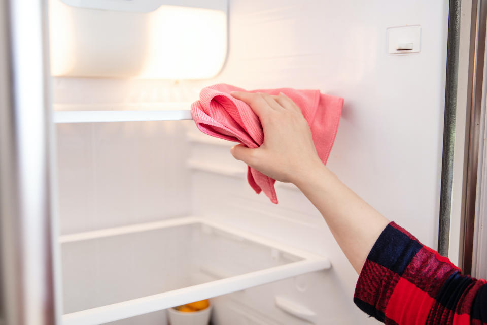 a hand cleaning a fridge