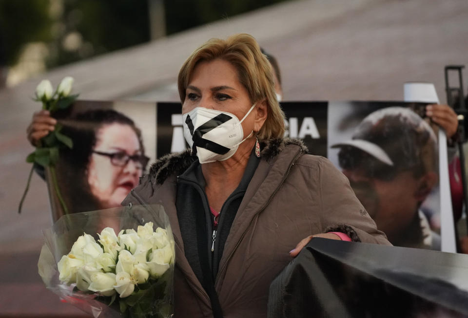 A woman joins a national protest against the murder of journalist Lourdes Maldonado and freelance photojournalist Margarito Martínez, at the Mexico monument in Tijuana, Mexico, Tuesday, Jan. 25, 2022. Mexico's Interior Undersecretary Alejandro Encinas said recently that more than 90% of murders of journalists and rights defenders remain unresolved, despite a government system meant to protect them. (AP Photo/Marco Ugarte)