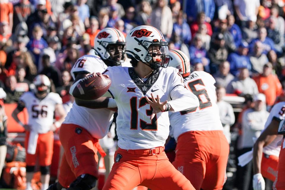 Oklahoma State Cowboys quarterback Garret Rangel (13) throws a pass against the Kansas Jayhawks during the first half of the game at David Booth Kansas Memorial Stadium.