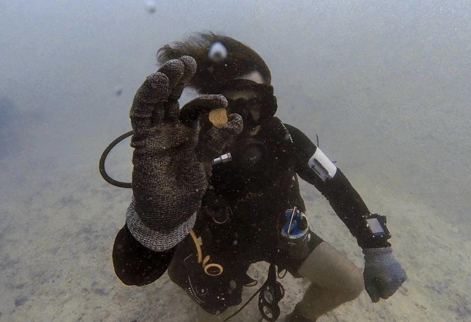 Zach Moore, a diver and engineer for Mel Fisher’s Treasures in Key West, shows off the rare gold coin he found July 16, 2021, while searching the wreck of a Spanish galleon that sank in 1622.