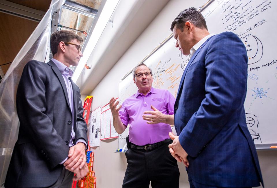 Professor David Baxter, chair of the Physics Department at Indiana University, talks with Sen. Todd Young, right, and Professor Phil Richerme, left, about the work done inside the quantum lab inside Simon Hall at Indiana University on Monday, May 8, 2023.