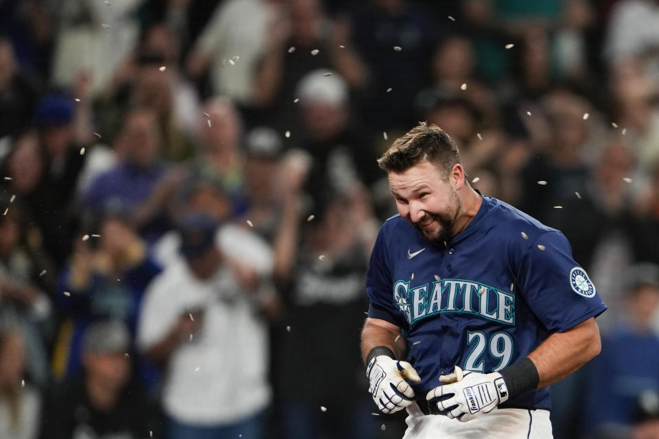 Seattle Mariners' Cal Raleigh runs through seeds thrown at him by teammates as he jogs home after hitting a game-winning grand slam during the ninth inning against the Chicago White Sox of a baseball game, Monday, June 10, 2024, in Seattle. The Mariners won 8-4. (AP Photo/Lindsey Wasson)