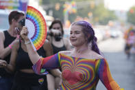 A participant walks along the parade route during the Pride Parade, Saturday, June 10, 2023, in Indianapolis. (AP Photo/Darron Cummings)