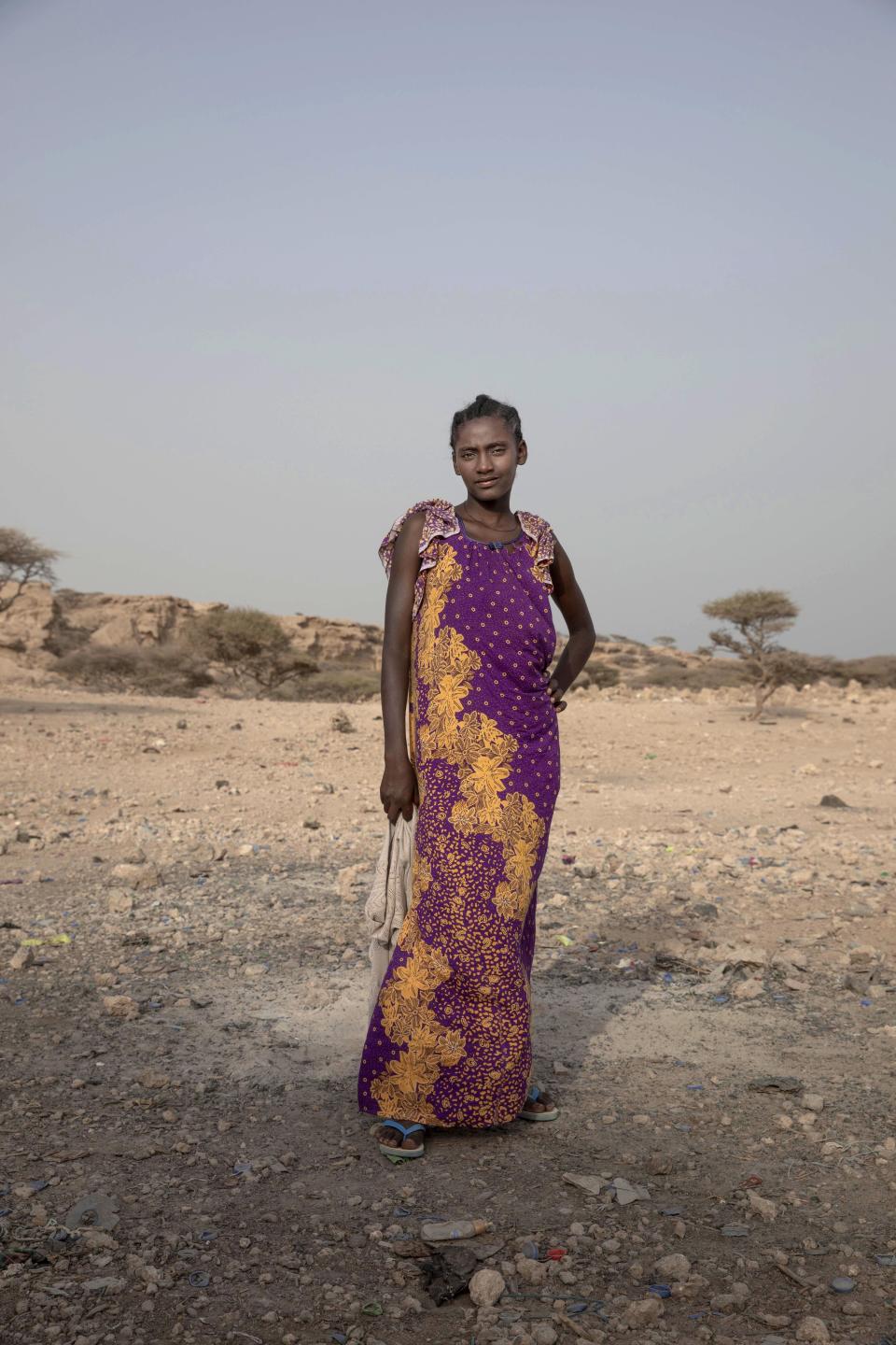 In this July 15, 2019 photo, 15-year old Medres, a migrant from Ethiopia, poses for a portrait, as she and others take shelter on the last stop of their journey before leaving by boat to Yemen in the evening, in Obock, Djibouti. She said she doesn't speak Arabic_ the majority language in the oil-rich Kingdom. She was told that she should be able to learn the language in one month. She could earn as much as 2500 to 3000 riyals, about 700 U.S. dollars. (AP Photo/Nariman El-Mofty)