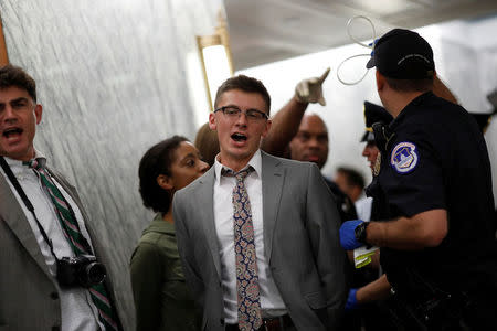 Capitol Police detain demonstrators as the Senate Finance Committee holds a hearing on the latest Republican Effort to repeal and replace the Affordable Care Act on Capitol Hill in Washington, U.S. September 25, 2017. REUTERS/Aaron P. Bernstein