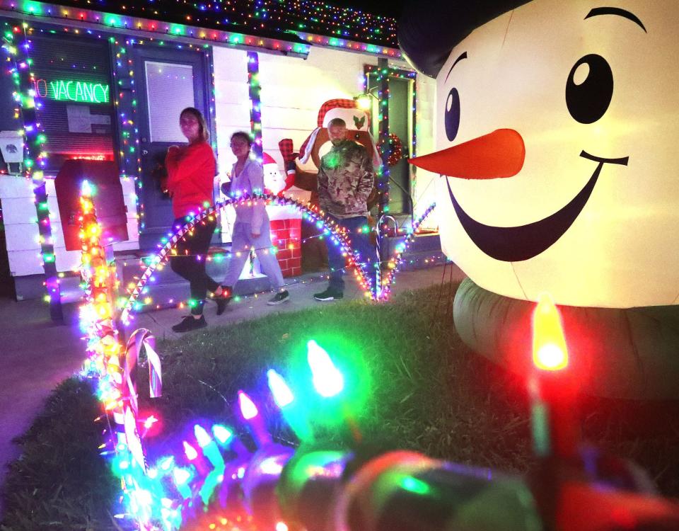 Visitors check out the Christmas decorations, Wednesday, Dec. 21, 2022, at the Twi-Light II Motel in Holly Hill. Motel co-owner Tammy Johnson said the over 300 decorations are meant to bring the Christmas "feel" to families. “They say they enjoy the decorations with their family,” Johnson said. “It’s something kids love, something (families) can all do together.”