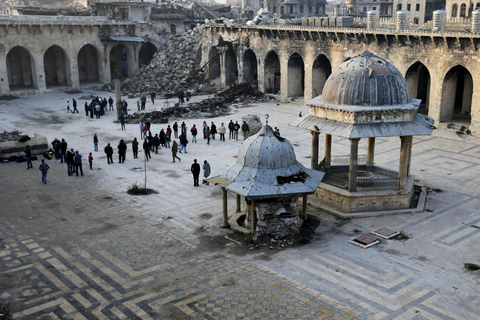 FILE - People visit the courtyard of the heavily damaged Great Mosque of Aleppo, also known as the Umayyad Mosque, in the Old City of Aleppo, Syria, Thursday, Jan. 19, 2017. For years, the people of Aleppo bore the brunt of bombardment and fighting when their city, once Syria's largest and most cosmopolitan, was one of the civil war's fiercest battle zones. Even that didn't prepare them for the new devastation and terror wreaked by this week's earthquake. (AP Photo/Hassan Ammar, File)