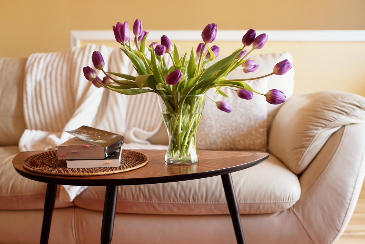  In a living room, a vase with tulips placed inside. 