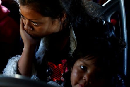 A migrant woman and a girl, part of a caravan of thousands traveling from Central America en route to the United States, sit in a bus while the bus stop for them to get food and water from a store on a highway in Culiacan, Mexico November 15, 2018. REUTERS/Kim Kyung-Hoon