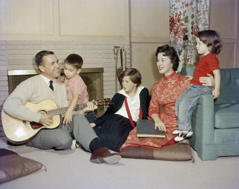 <p>Shirley relaxes with her family, including her husband Charles and her three children, in the living room of their California home.</p>