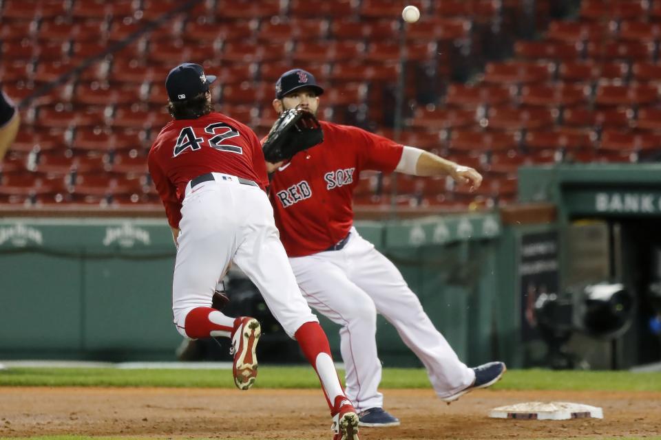 Boston Red Sox's Chris Mazza, left, makes a throwing error to Mitch Moreland on a single by Washington Nationals' Juan Soto during the third inning of a baseball game, Saturday, Aug. 29, 2020, in Boston. (AP Photo/Michael Dwyer)