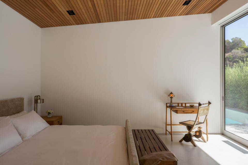 All the rooms in the home benefit from abundant sunlight, as seen in this bedroom. The bed and bedside table were custom designed by Applebaum; the desk is by Jacques Adnet, with a lamp from Marcel Breuer and a chair by Carlo Bugatti sourced from Blackman Cruz. Crisp bed linens by Frette complete the tranquil space.
