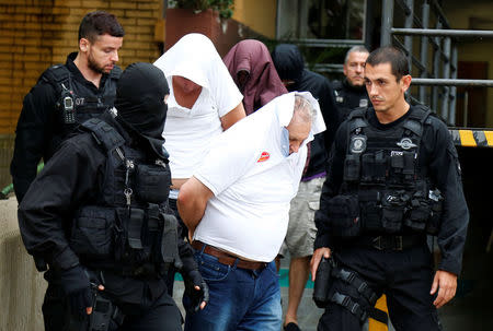 People detained during the probe known as "Operation Weak Flesh" are escorted by police officers as they leave the Institute of Forensic Science in Curitiba, Brazil March 17, 2017. REUTERS/Rodolfo Buhrer