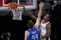 Dallas Mavericks forward Nicolo Melli (44) is unable to stop San Antonio Spurs guard Lonnie Walker IV (1) from dunking in the second half of an NBA basketball game in Dallas, Sunday, April 11, 2021. (AP Photo/Tony Gutierrez)