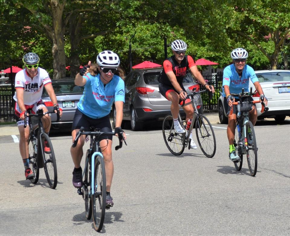 Battle Creek's Nicole Jaeger, front, rides into town on Tuesday as she nears the end of her 2,000-plus mile 'Ride For Poppy' that has seen her ride her bike from Oregon to Michigan in an effort to raise money for cancer research in honor of her late father.