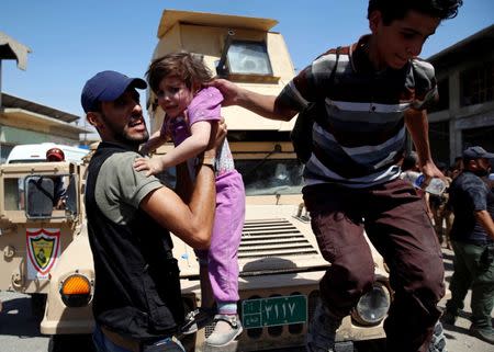 A medical worker carries a girl who are among displaced civilians rescued by Iraqi security forces at Old City in western Mosul, Iraq June 23, 2017. REUTERS/Erik De Castro