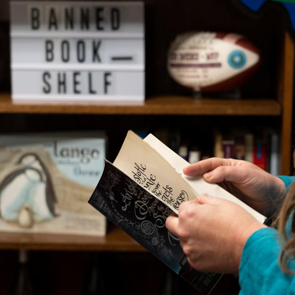 Rep. Erin Zwiener flips through one of the books from her banned book collection.