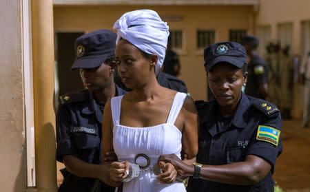 Diane Shima Rwigara, a prominent critic of Rwanda's president Paul Kagame, is escorted by police officers into a courtroom in Kigali, Rwanda October 11, 2017. REUTERS/Jean Bizimana