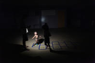 <p>Children play in the light of a flashlight at a school turned shelter, after their home was destroyed when Hurricane Maria hit the island in September, in Toa Baja, Puerto Rico, Oct.18, 2017. (Photo: Alvin Baez/Reuters) </p>