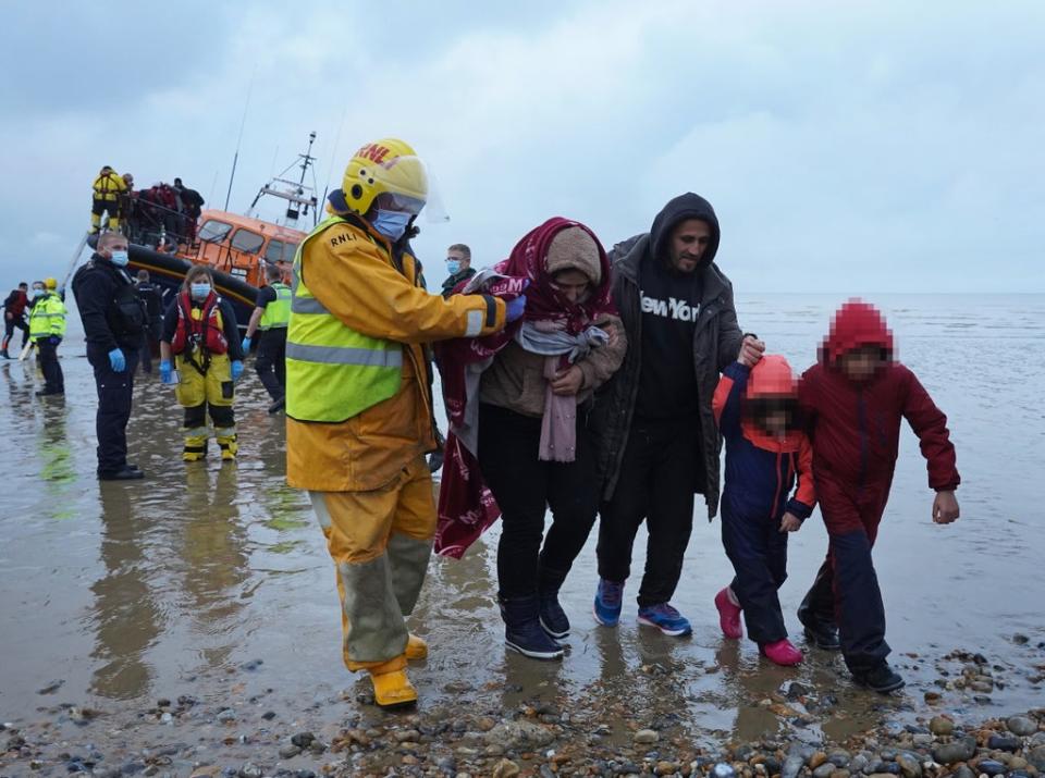 A family is helped to shore as a group of people thought to be migrants are brought in to Dungeness, Kent, by the RNLI following a small boat incident in the Channel (Gareth Fuller/PA) (PA Wire)