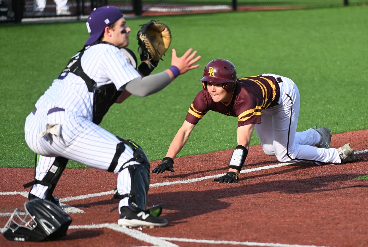 Bloomington North’s Luke Freel slides past Bloomington South catcher Ben Ridner to score during the baseball game at South on Thursday, April 25, 2024.