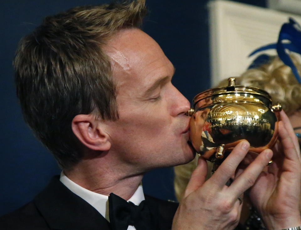 Actor Neil Patrick Harris kisses the Hasty Pudding Pot during his celebration as Man of The Year by Harvard University's Hasty Pudding Theatricals in Cambridge, Mass., Friday, Feb. 7, 2014. (AP Photo/Elise Amendola)