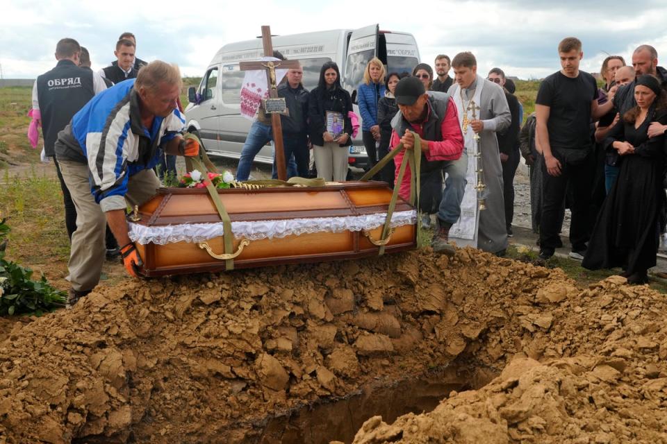 Men lower the coffin of Liza, four-year-old girl killed by Russian attack, during a funeral ceremony in Vinnytsia, Ukraine (AP)