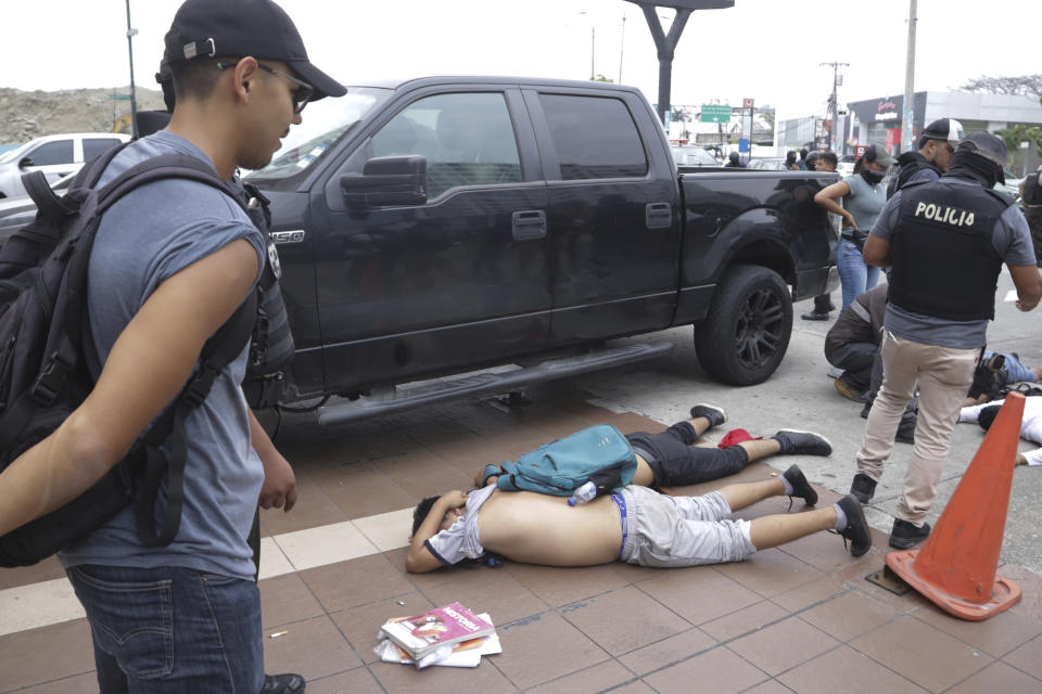 Hombres yacen boca abajo en el suelo detenidos por policías afuera de TC Televisión, luego de que un productor le dijera a la policía que formaban parte de un grupo que irrumpió en su set durante una transmisión en vivo, en Guayaquil, Ecuador, el martes de 9 de enero de 2024. (Foto AP/César Muñoz)
