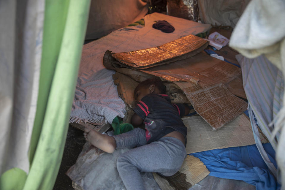 A girl sleeps in a makeshift tent at the Devirel camp, six months after a 7.2 magnitude earthquake in Les Cayes, Haiti, Wednesday, Feb. 16, 2022. Thousands of Haitians who lost their homes in the quake remain in camps, living in cramped shelters made of plastic and cloth sheets and corrugated metal. (AP Photo/ Odelyn Joseph)