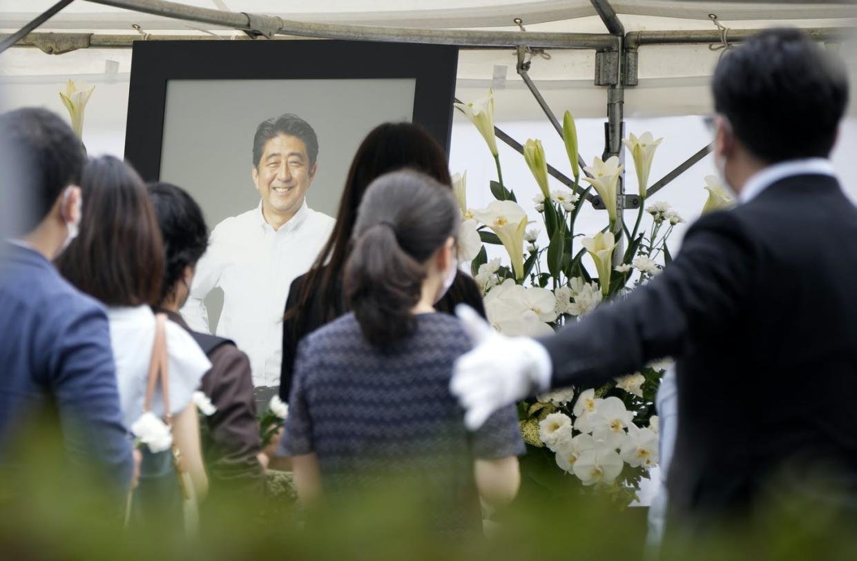 <span>People line up to pay their respects before the funeral of former Prime Minister Shinzo Abe, on July 12, 2022, at Zojoji Temple in Tokyo.</span> <span><a href="https://newsroom.ap.org/detail/Japan/23bee50a27e14cb68997309edebd0398/photo?Query=shinzo%20abe&mediaType=photo&sortBy=&dateRange=Anytime&totalCount=14402&currentItemNo=37" rel="nofollow noopener" target="_blank" data-ylk="slk:AP Photo/Eugene Hoshiko;elm:context_link;itc:0;sec:content-canvas" class="link ">AP Photo/Eugene Hoshiko</a></span>